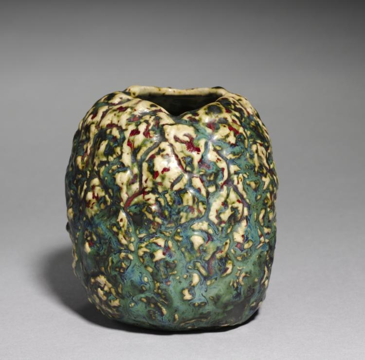 A rounded short vase with a small opening and dense yellow, green and blue markings.